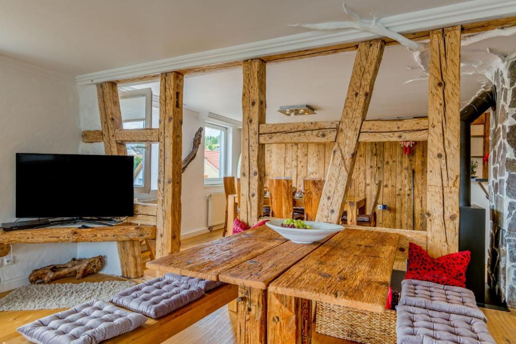 sala de estar con mesa de madera y TV en Zum Kuckuck, en Schonach