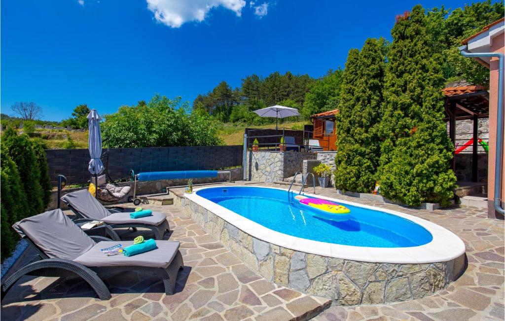 una piscina con 2 sillas y una sombrilla en Awesome Home In Pasjak With Outdoor Swimming Pool, en Pasjak