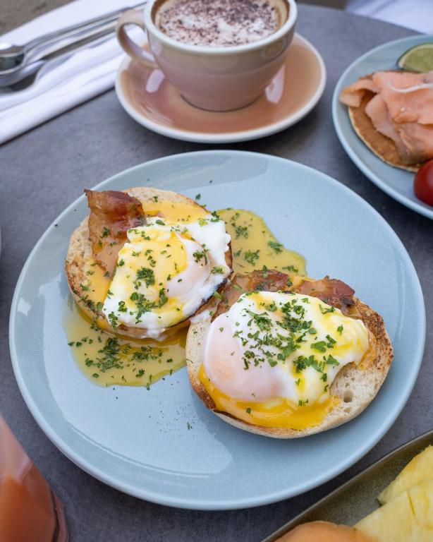two eggs on a plate with a cup of coffee at The 1932 Hotel & Spa Cap d'Antibes - MGallery Collection in Juan-les-Pins
