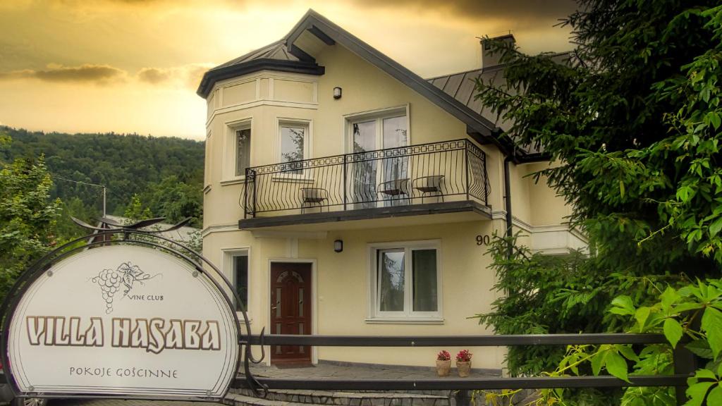 Uma casa branca com um cartaz à frente. em Villa Hasaba em Krościenko