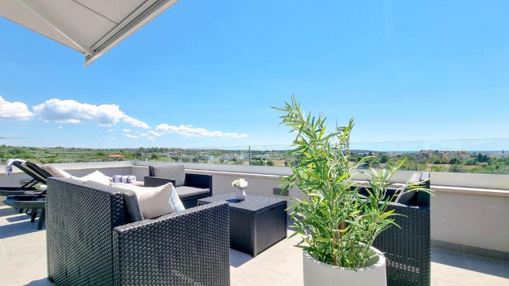 een patio met rieten stoelen en tafels op een balkon bij Casa Mia in Novigrad Istria