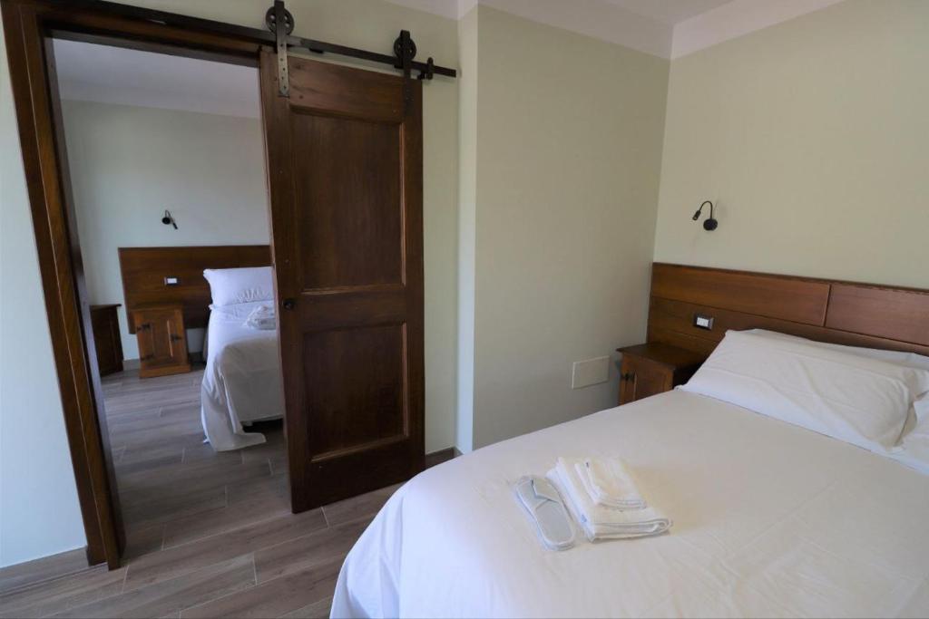 a bedroom with a white bed and a mirror at Casale Sienti'n Può in Norcia