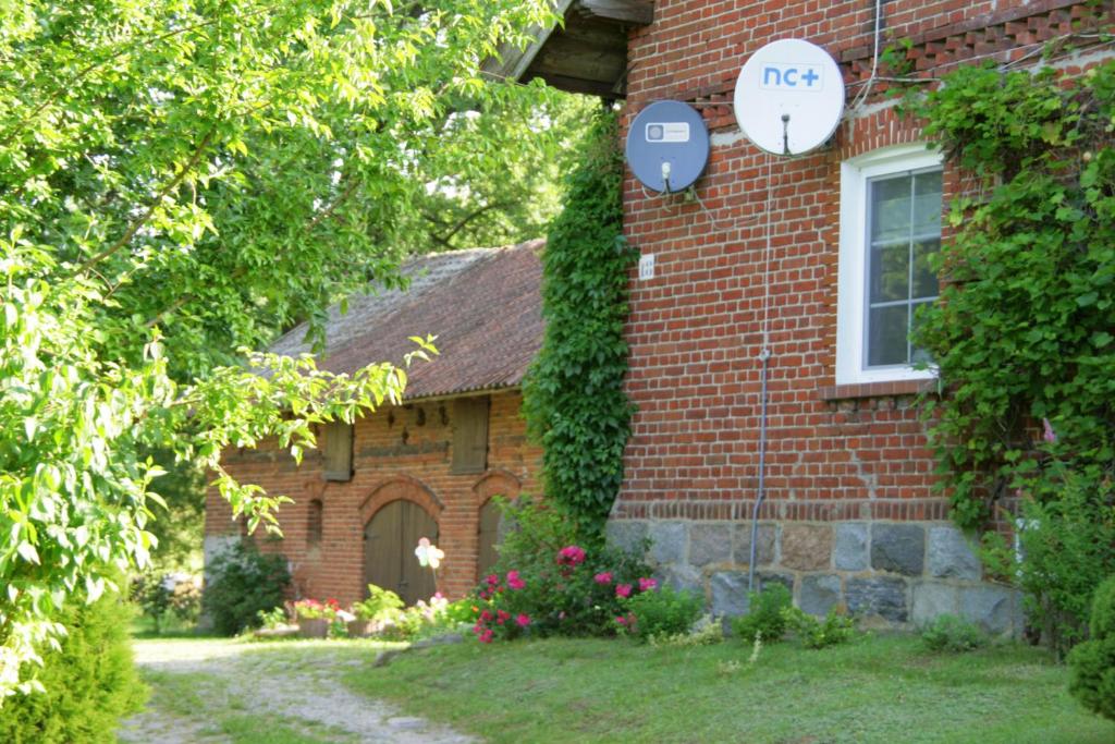 Una casa de ladrillo con un cartel en el costado. en Agroturystyka Pod Dębem en Jonkowo