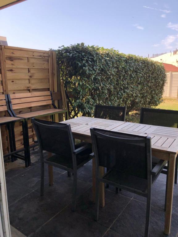 une table et des chaises en bois sur une terrasse dans l'établissement sainte cecile, à Sainte-Cécile-Plage