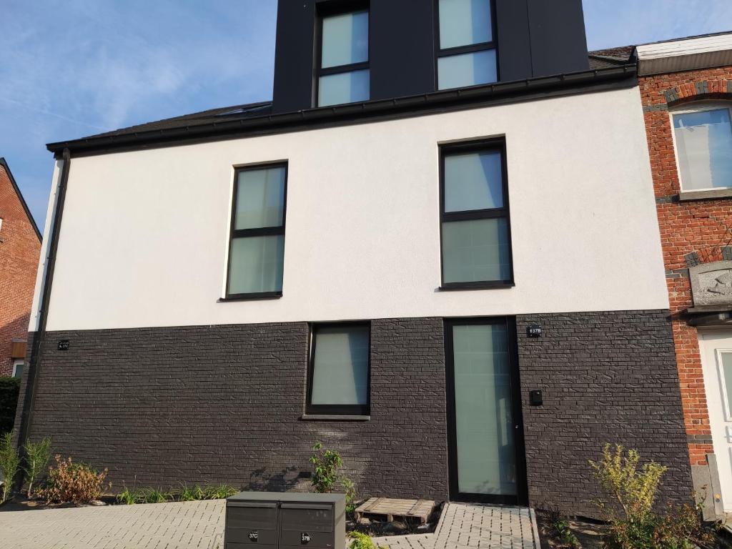 une maison avec des fenêtres en noir et blanc dans l'établissement Gasthuis Puytvoet, à Saint-Nicolas