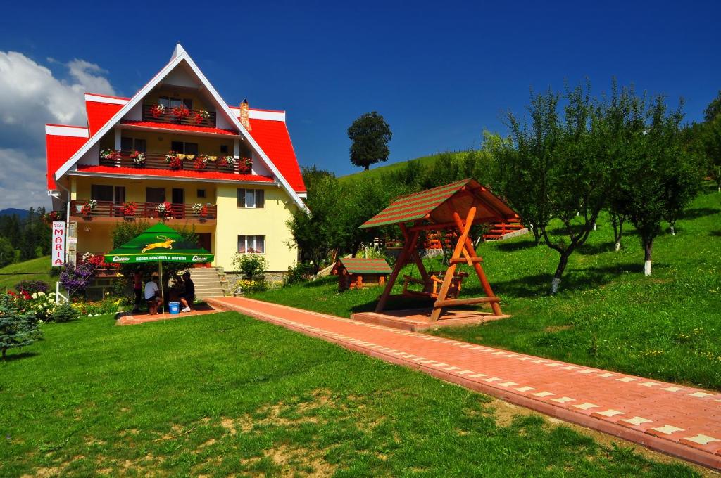 um edifício com um parque infantil em frente em Pensiunea Maria em Durau