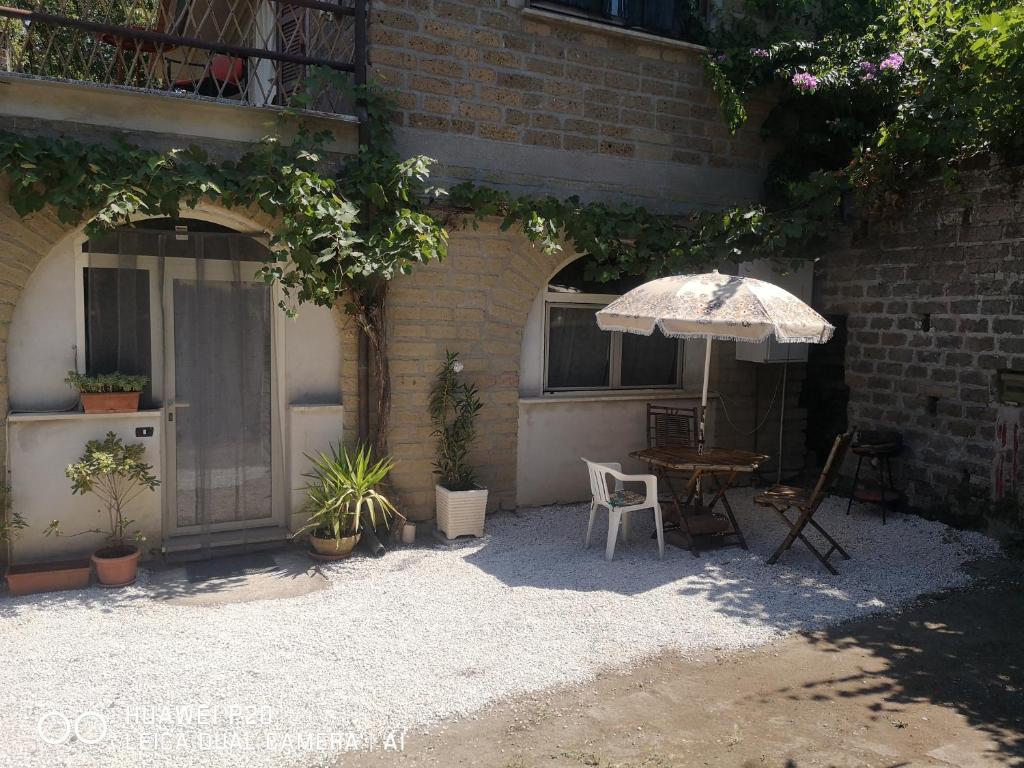 a patio with an umbrella and a table and chairs at Ape Regina agriturismo 2 Montelarco in Rignano Flaminio
