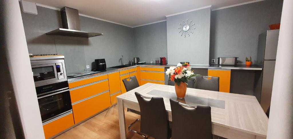 una cucina con tavolo e vaso di fiori di Appartement au coeur de Calais a Calais