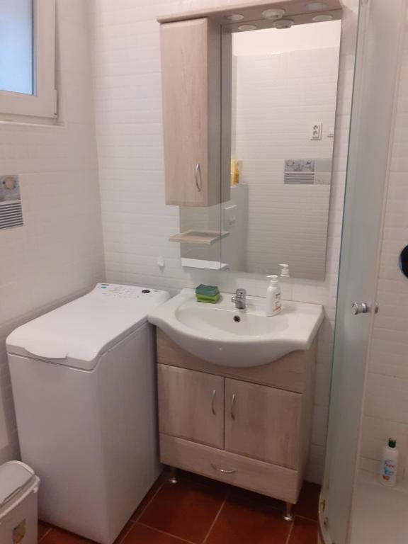 een witte badkamer met een wastafel en een toilet bij Budapest City Bridge Apartman in Boedapest