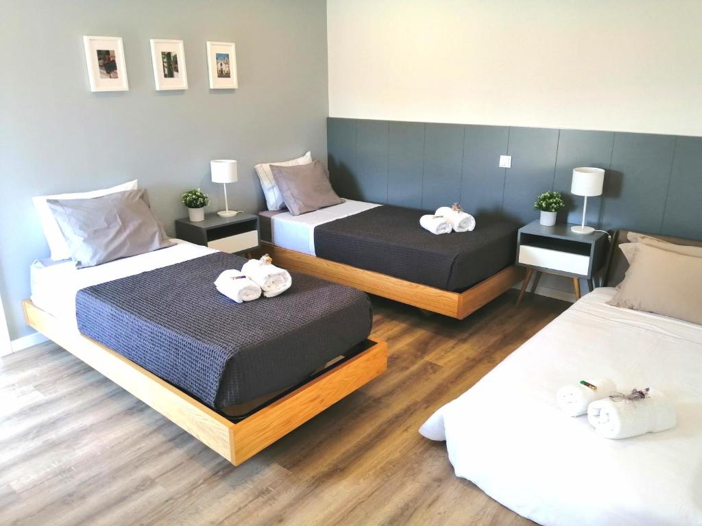 um quarto com duas camas com toalhas em Jardim das Oliveiras - Suítes com Vista em Ponte de Lima