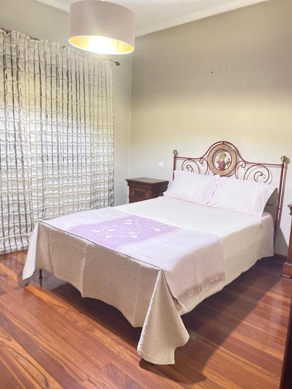 CASA CAMPO DA FEIRA في فيلجويراس: غرفة نوم بسرير كبير مع بطانية بيضاء