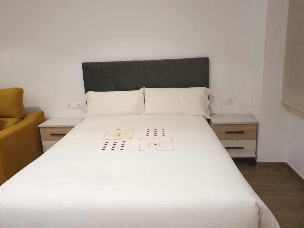 1 dormitorio con 1 cama blanca y 2 mesitas de noche en Apartamento María Mendoza en Ardales