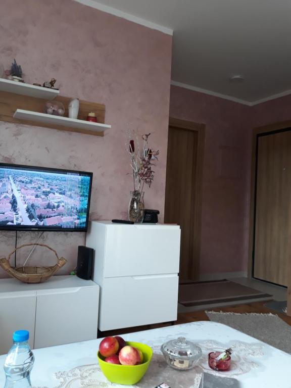 a living room with a television and a table with fruit at Stašenka apartment in Zlatibor