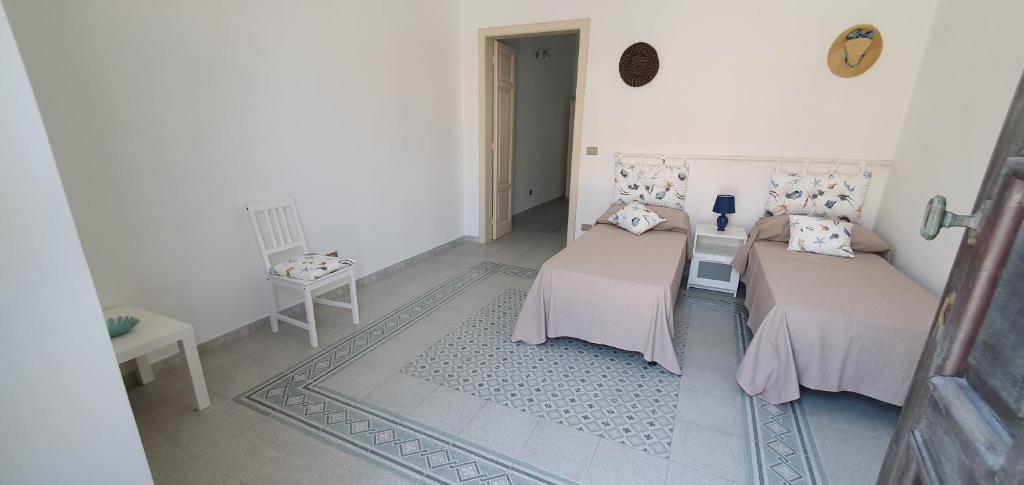 a room with two beds and a table in it at A 2 passi dal mare - grazioso trilocale a Locri in Locri