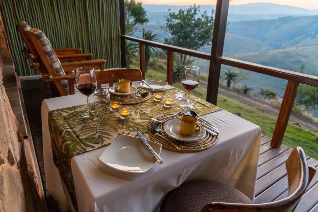 a table with glasses of wine on a balcony at Gwahumbe Game & Spa in Mid Illovo