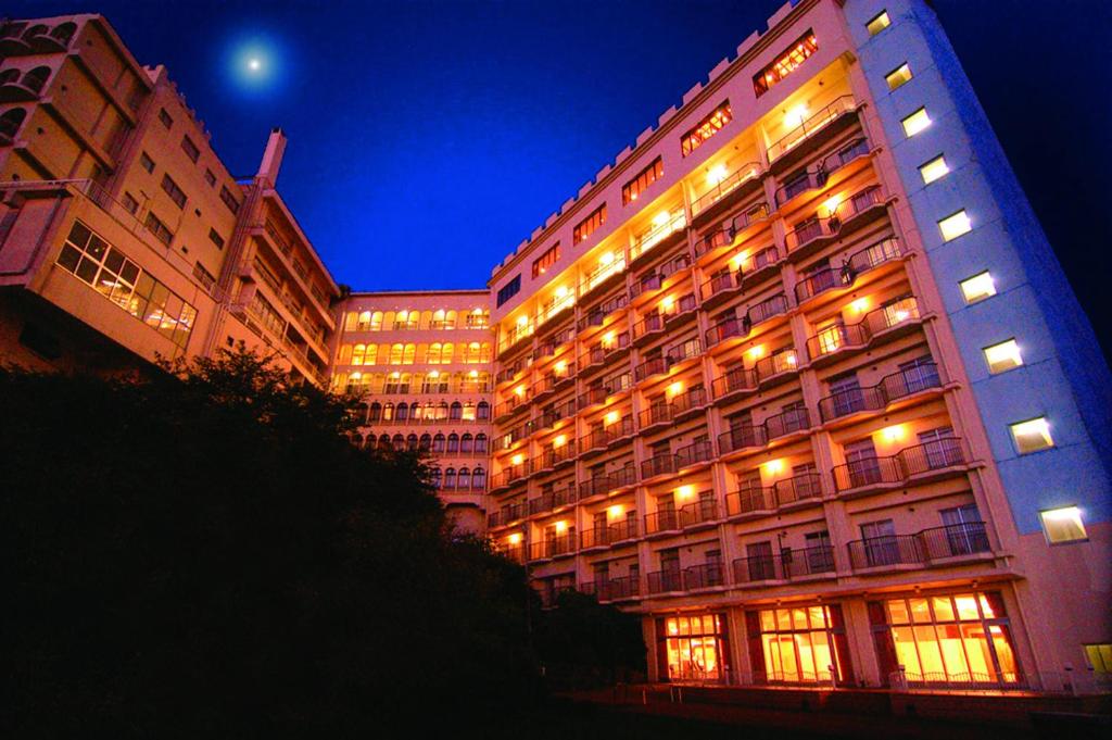 un gran edificio con ventanas iluminadas por la noche en Yataro en Nagasaki