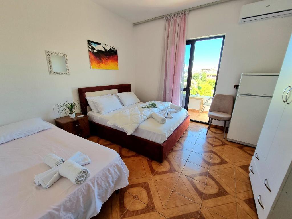 ドゥラスにあるGUEST HOUSE VILA ELEZIのベッドルーム1室(ベッド2台付)、バルコニーが備わります。