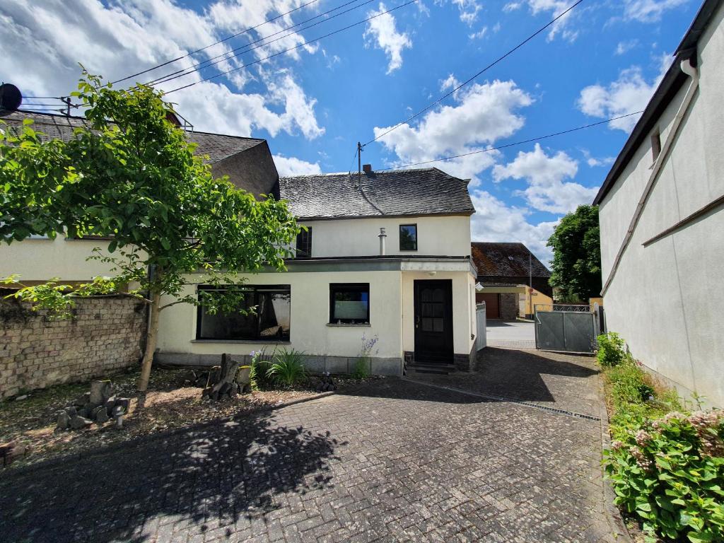 een wit huis met een boom op de oprit bij Ferienhaus Welling in Welling