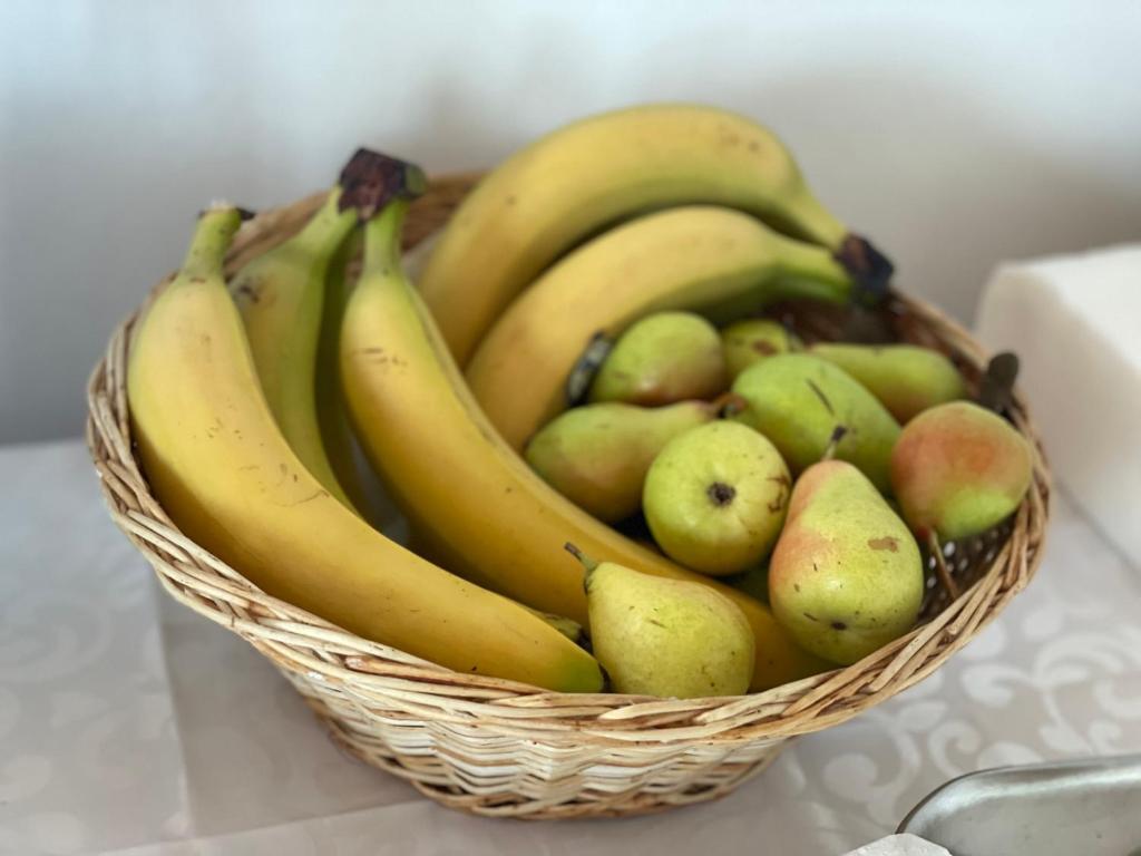 a basket of bananas apples and pears on a counter at SEA & LAKE VIEW VILLA in (( Kalive Gjoka ))