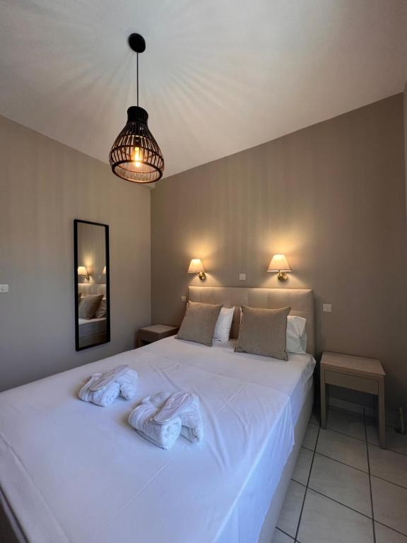 スカラ・エレソスにあるFenareti Apartmentsのベッドルーム1室(白いベッド1台、タオル付)