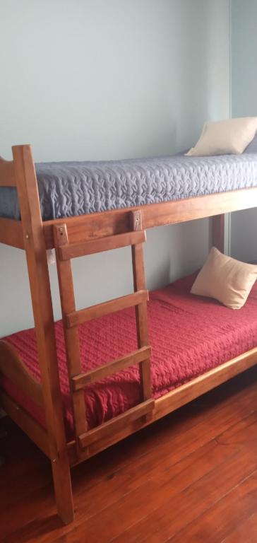 a bunk bed in a room with a red mattress at Ushuaia de las Nieves B&B in Ushuaia