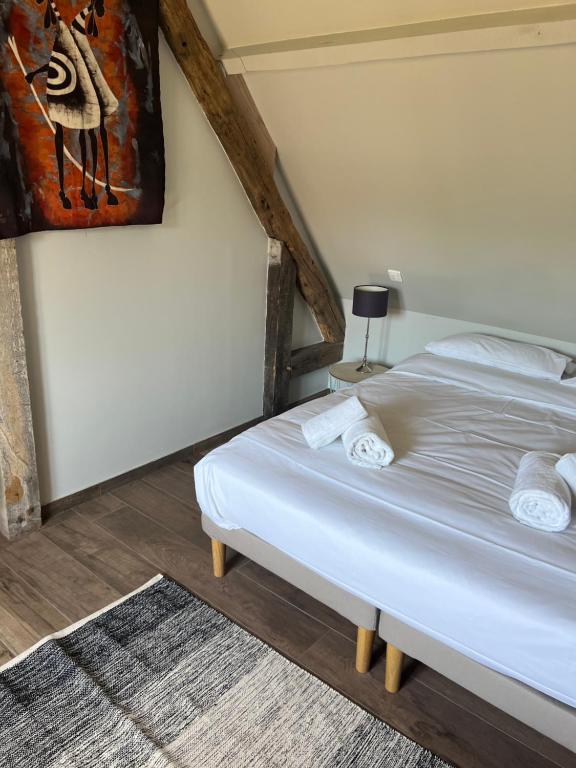 Un dormitorio con una cama y un cuadro en la pared. en Le domaine des Bois, en Blangy-le-Château