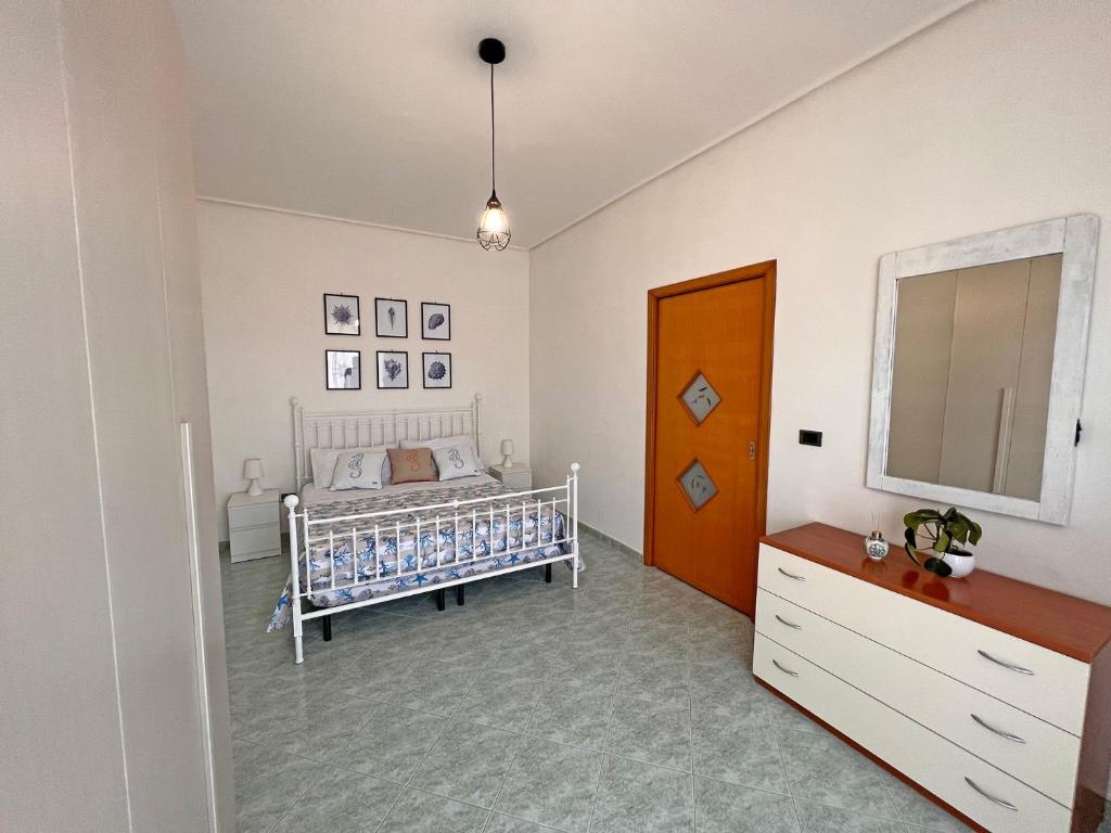 1 dormitorio con cuna, tocador y espejo en Domus Arianna, en Castellammare di Stabia