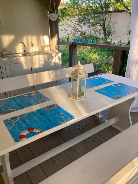 een witte tafel met een lantaarn erop bij Синеморец Каравана Paradise in Sinemorets