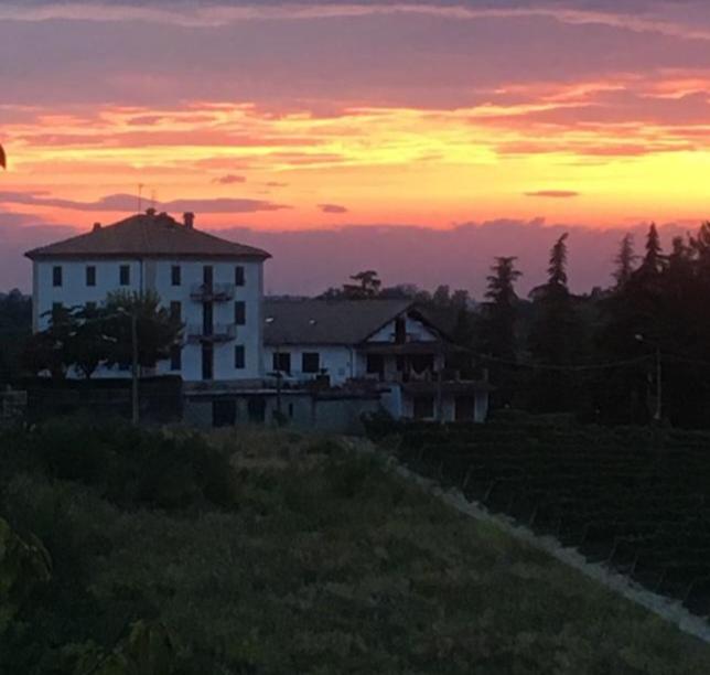 een huis op een heuvel met een zonsondergang op de achtergrond bij La Casa di Bacco B&B in Lerma