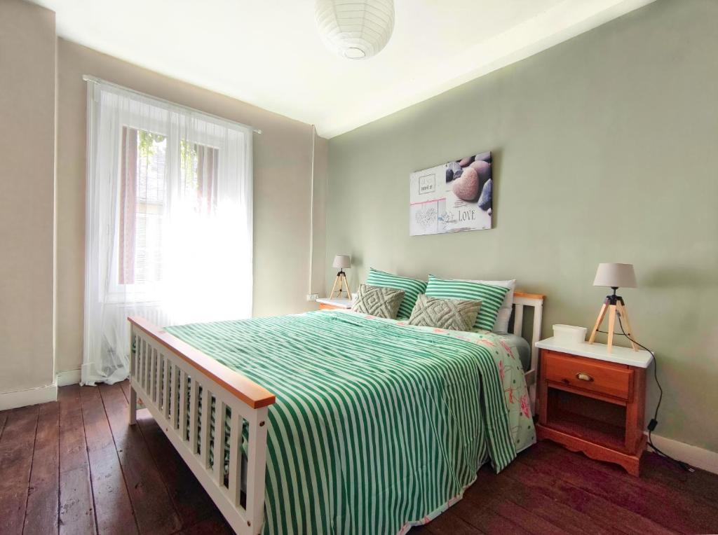 1 dormitorio con 1 cama con manta verde y blanca en Number 22 - Le Dorat - Apartment 3, en Le Dorat