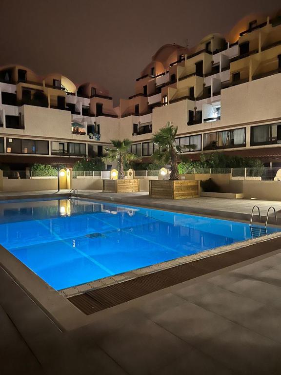 une piscine devant un immeuble la nuit dans l'établissement Escale à Gruissan au coeur de la Marina, à Gruissan