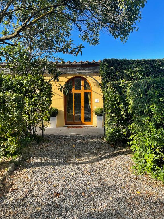 a house with a yellow door and a hedge at la limonaia in Florence