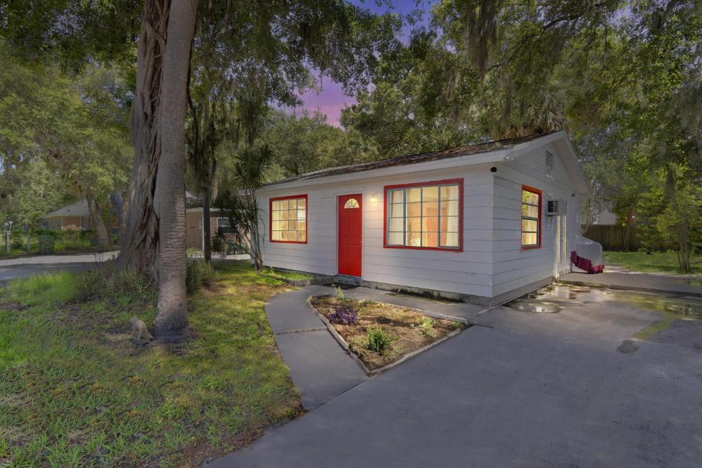 a small white tiny house with a red door at Downtown Single Family Modern Bungalow close to beaches and dining home in Sarasota