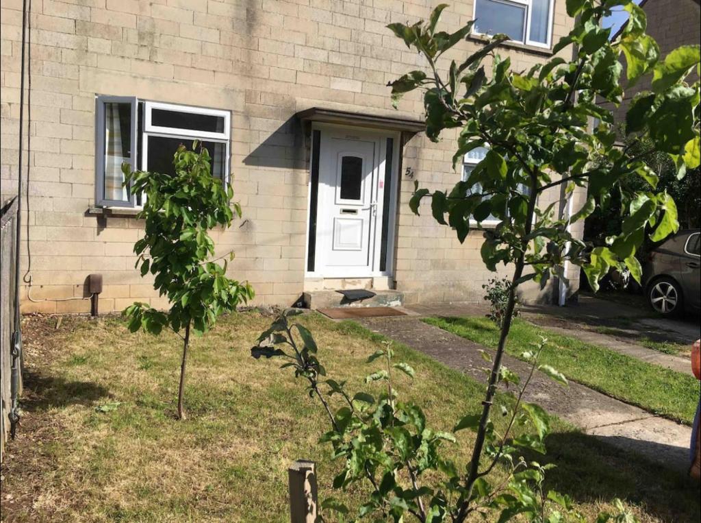 une maison avec une porte blanche et un arbre dans l'établissement Nikolay’s House, à Bristol