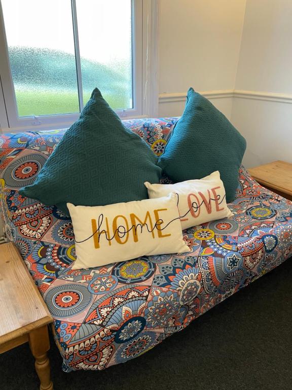 un sofá con almohadas con las palabras del hogar escritas en él en Cozy 3 Bedrooms Home off Mill Road Sleep up to 6, en Cambridge