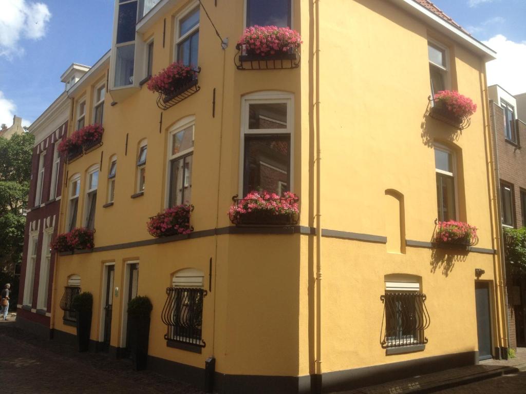 a yellow building with flower boxes on the side of it at In de Steenstraat in Zwolle