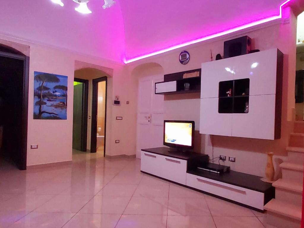 een woonkamer met een tv en roze verlichting bij INTERNO 13 Apartament in Spinazzola