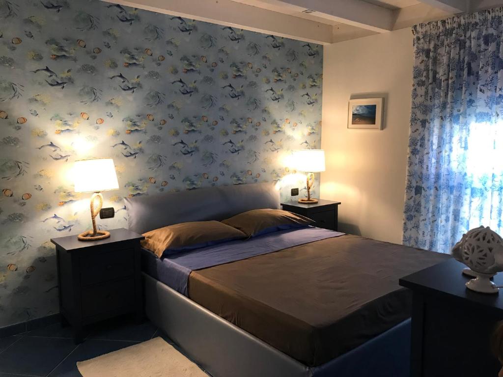 una camera da letto con un letto con fiori blu sul muro di Tartaruga House a Policoro