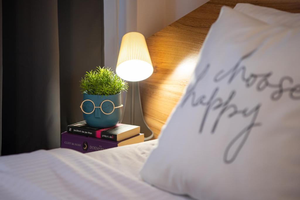 a plant on top of a book next to a bed at Henriett’s cosy place in Satu Mare