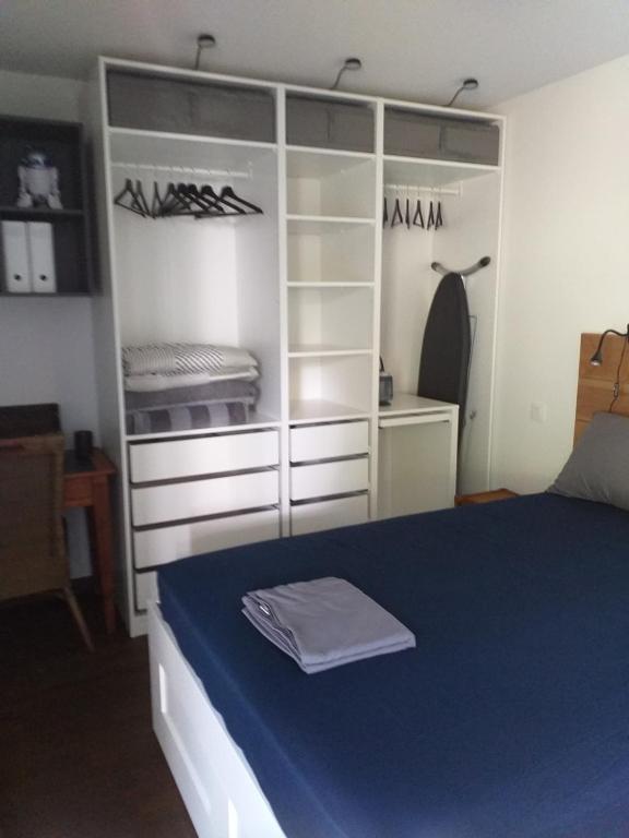 1 dormitorio con 1 cama con manta azul y estanterías en PATIO ARENA F2, en Bayona