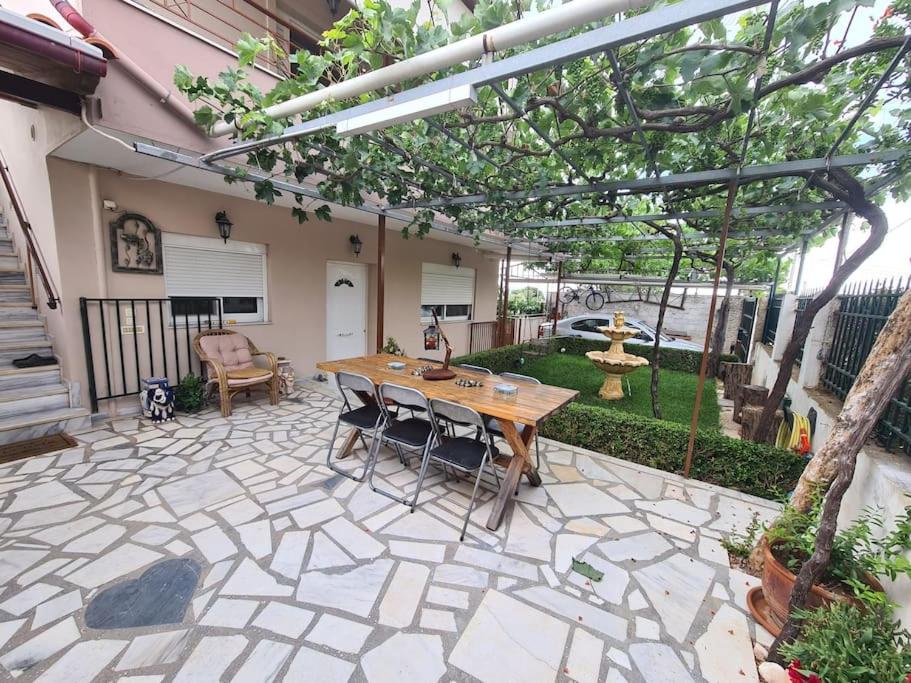 d'une terrasse avec une table et des chaises en bois dans la cour. dans l'établissement Village Giorgos, à Áyios Spirídhon