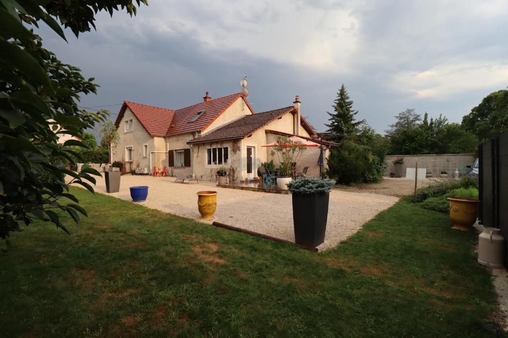 a house with a red roof on a driveway at gite des 3 rivières in Longeault