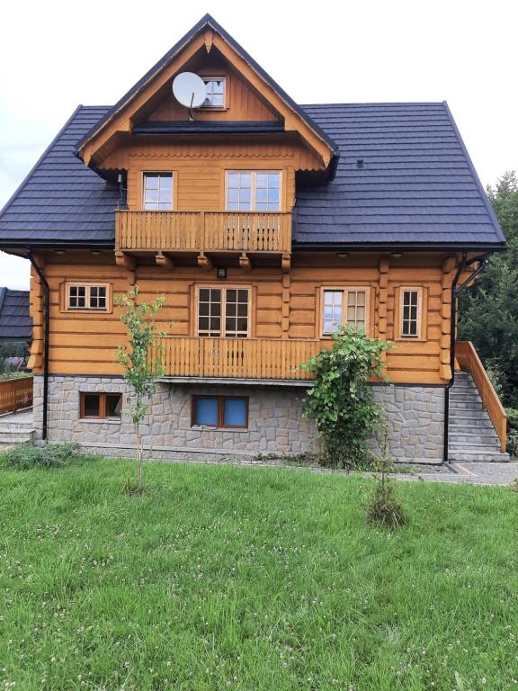 una casa de madera con balcón en la parte superior. en Willa Mosorniak, en Zawoja