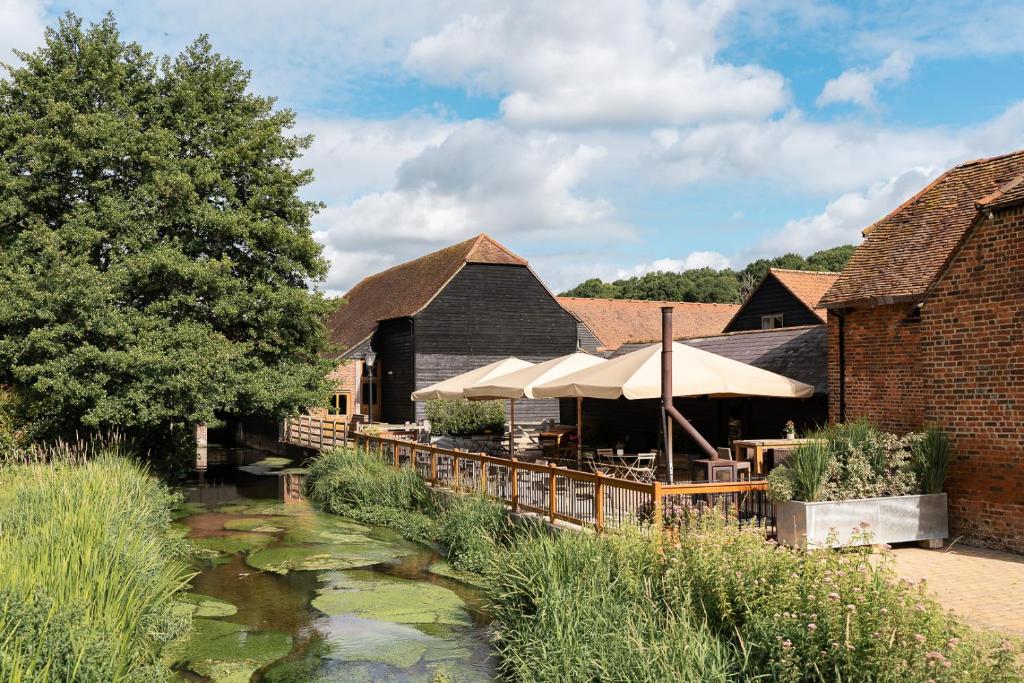 a restaurant with a pond in front of a building at Tewinbury in Tewin