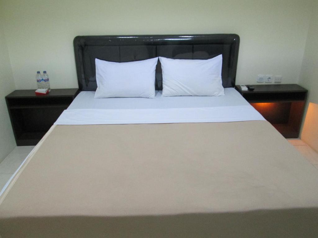 Postel nebo postele na pokoji v ubytování Mahkota Hotel