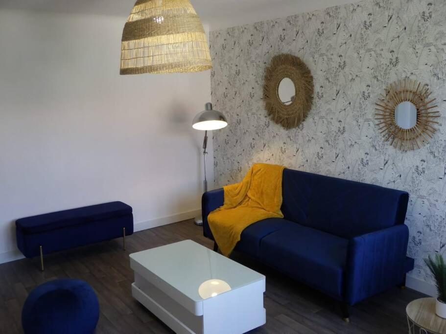 sala de estar con sofá azul y mesa en Spacieux appartement au pied de la cité médiévale en Carcassonne