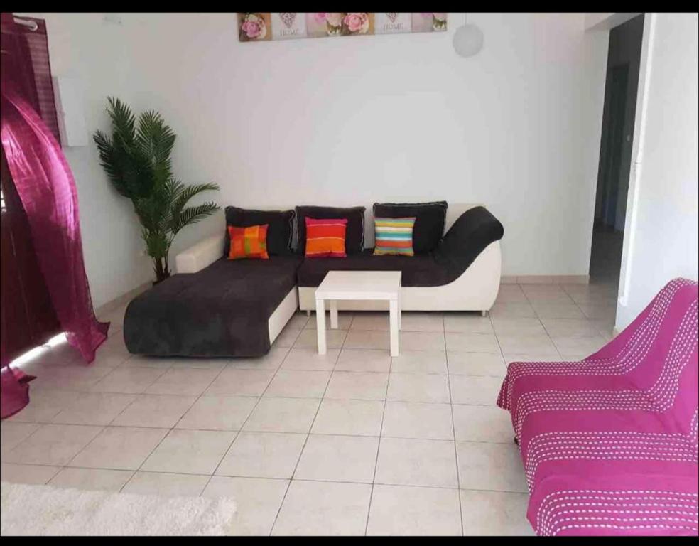 sala de estar con sofá y mesa en Caraibes, en Les Trois-Îlets