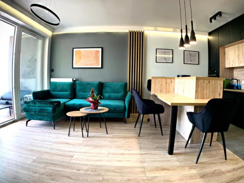 ein Wohnzimmer mit einem grünen Sofa und einem Tisch in der Unterkunft Loftowe UkieLove in Olsztyn
