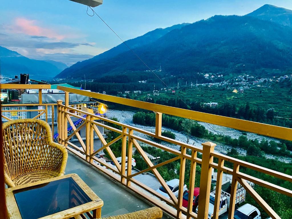 a chair on a balcony with a view of a mountain at Vashisht valley hotel in Manāli