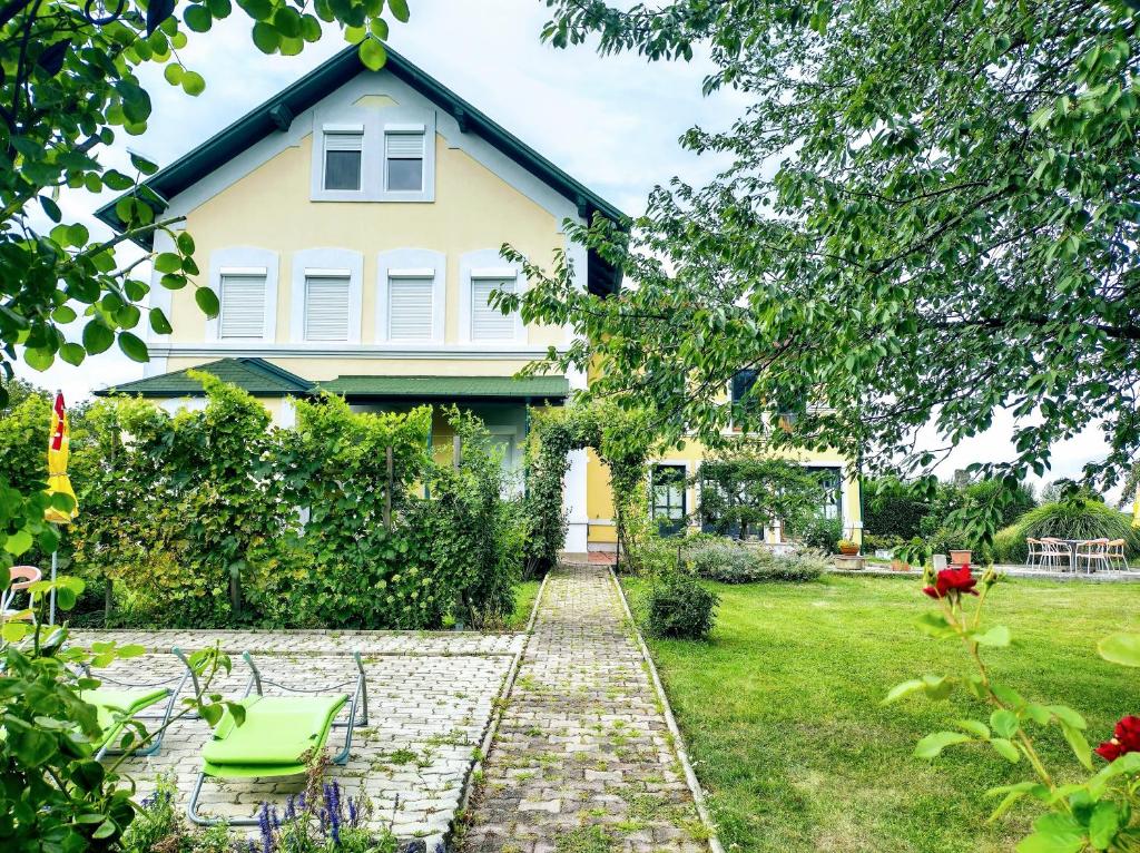 a house with a brick walkway in front of a yard at Das Sonnengleis in Lutzmannsburg